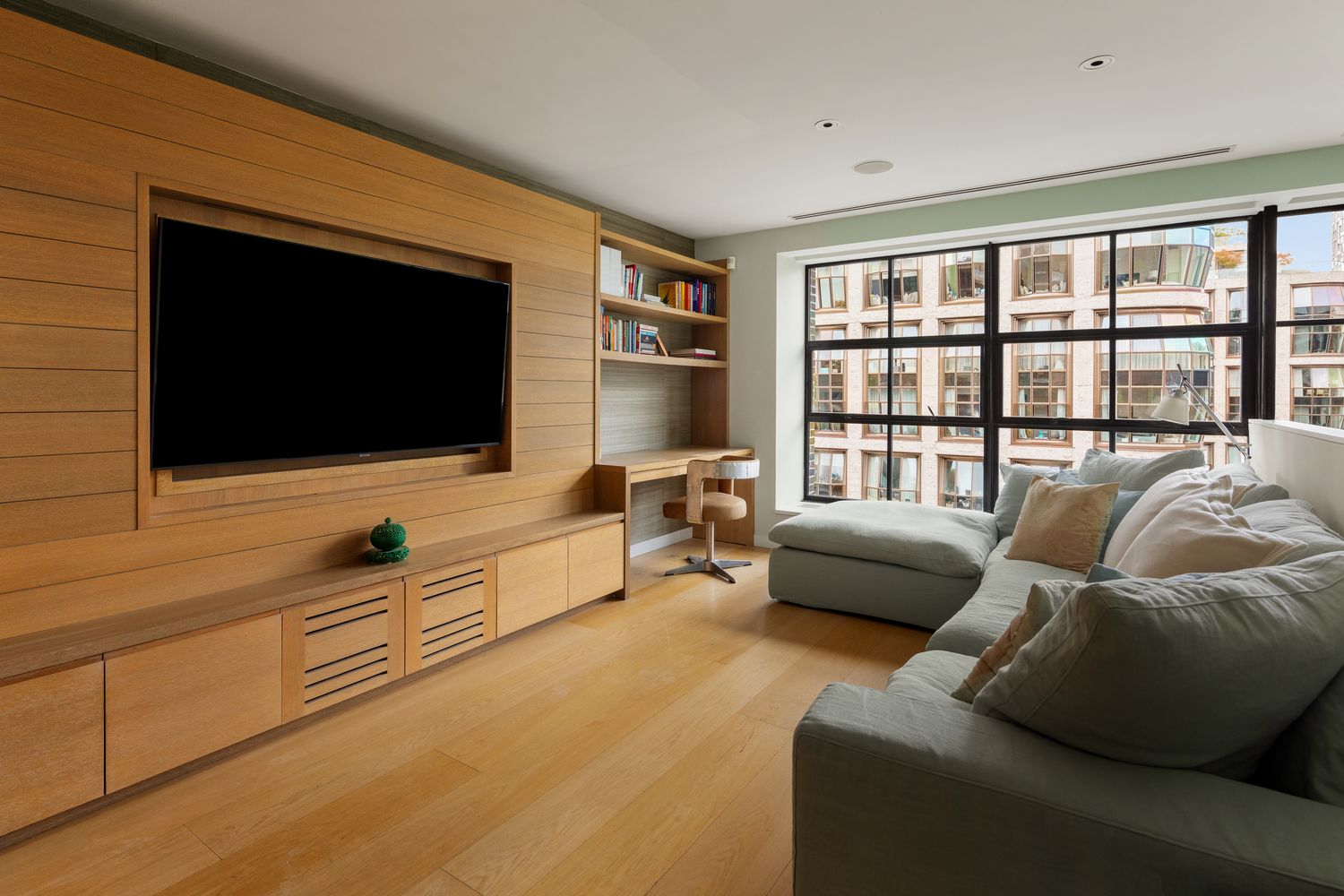 456 West 19th Street, Unit 6/7F Manhattan, NY 10011 - Photo 9 of 13 a living room with furniture and a flat screen tv