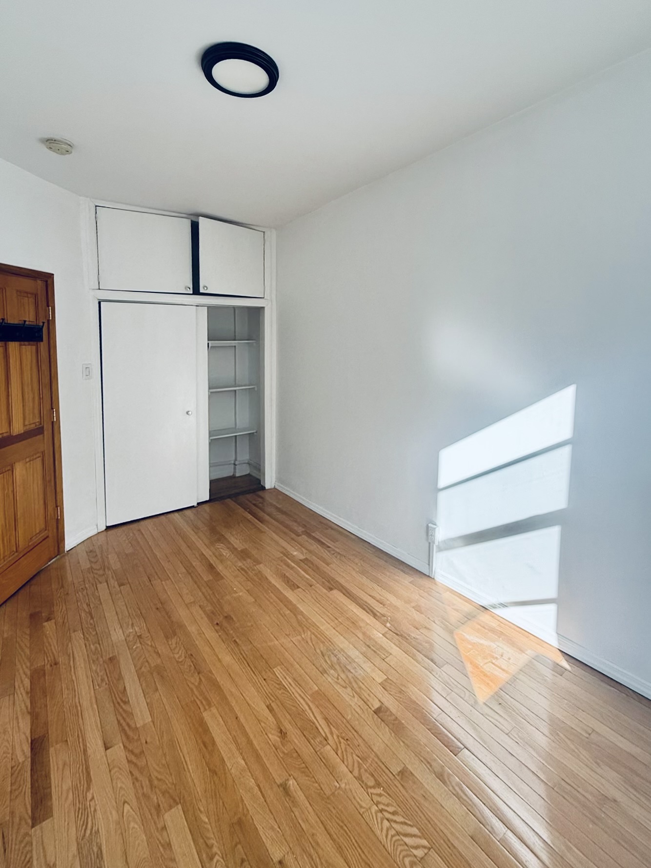 18-48 21st Drive, Unit 1R Queens, NY 11105 - Photo 2 of 11 a view of empty room with wooden floor