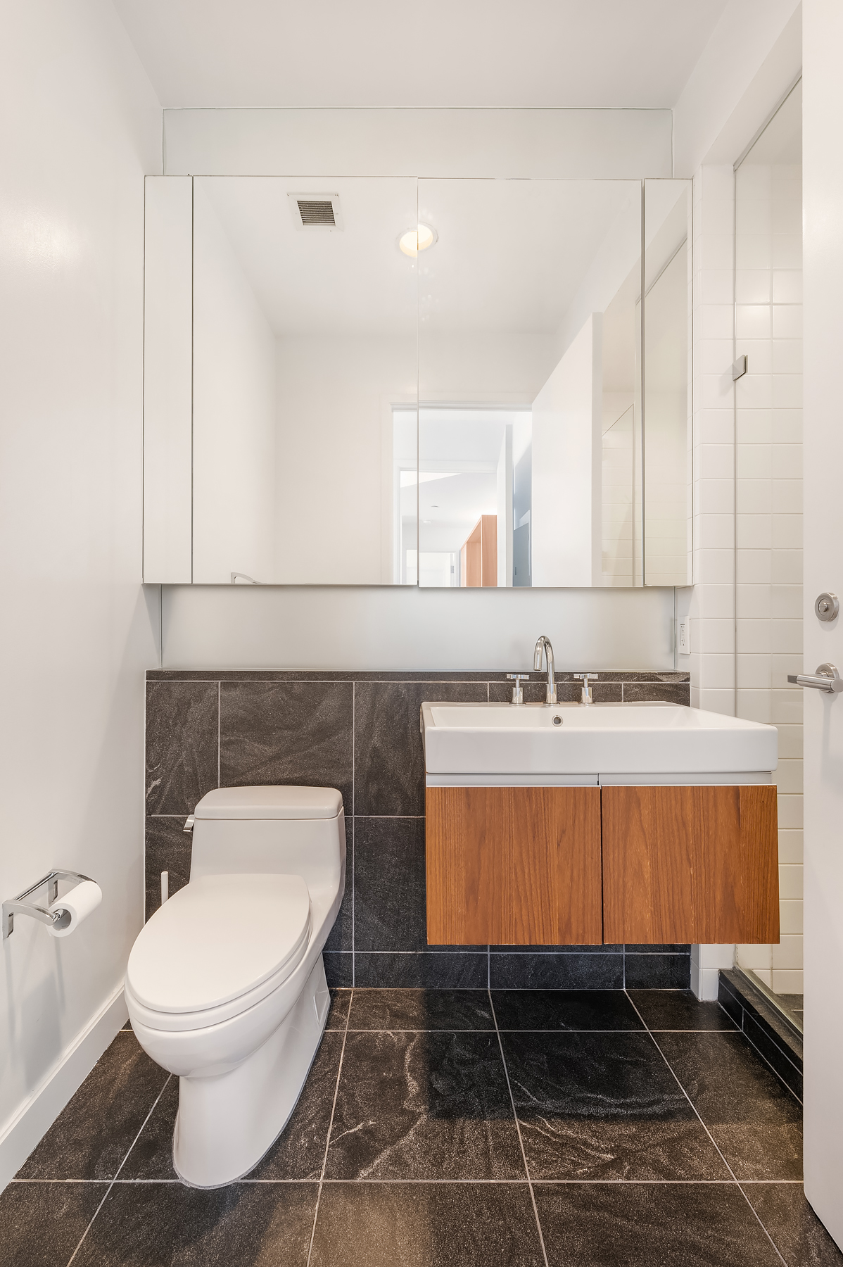 311 West Broadway, Unit 4G Manhattan, NY 10013 - Photo 4 of 8 a spacious bathroom with a toilet a sink and mirror