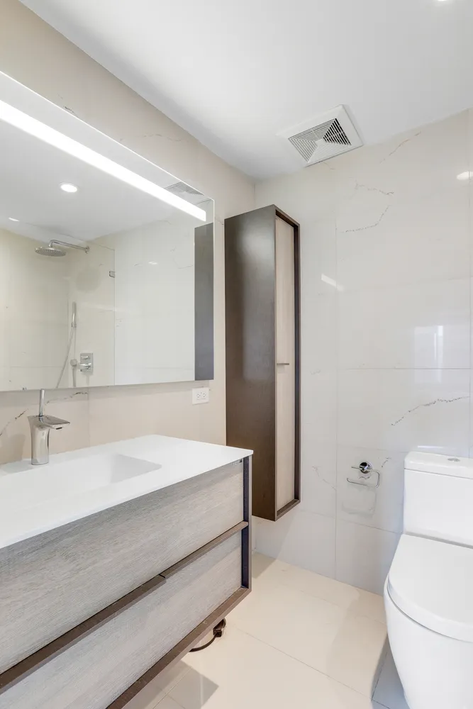 a bathroom with a sink a toilet and a large mirror