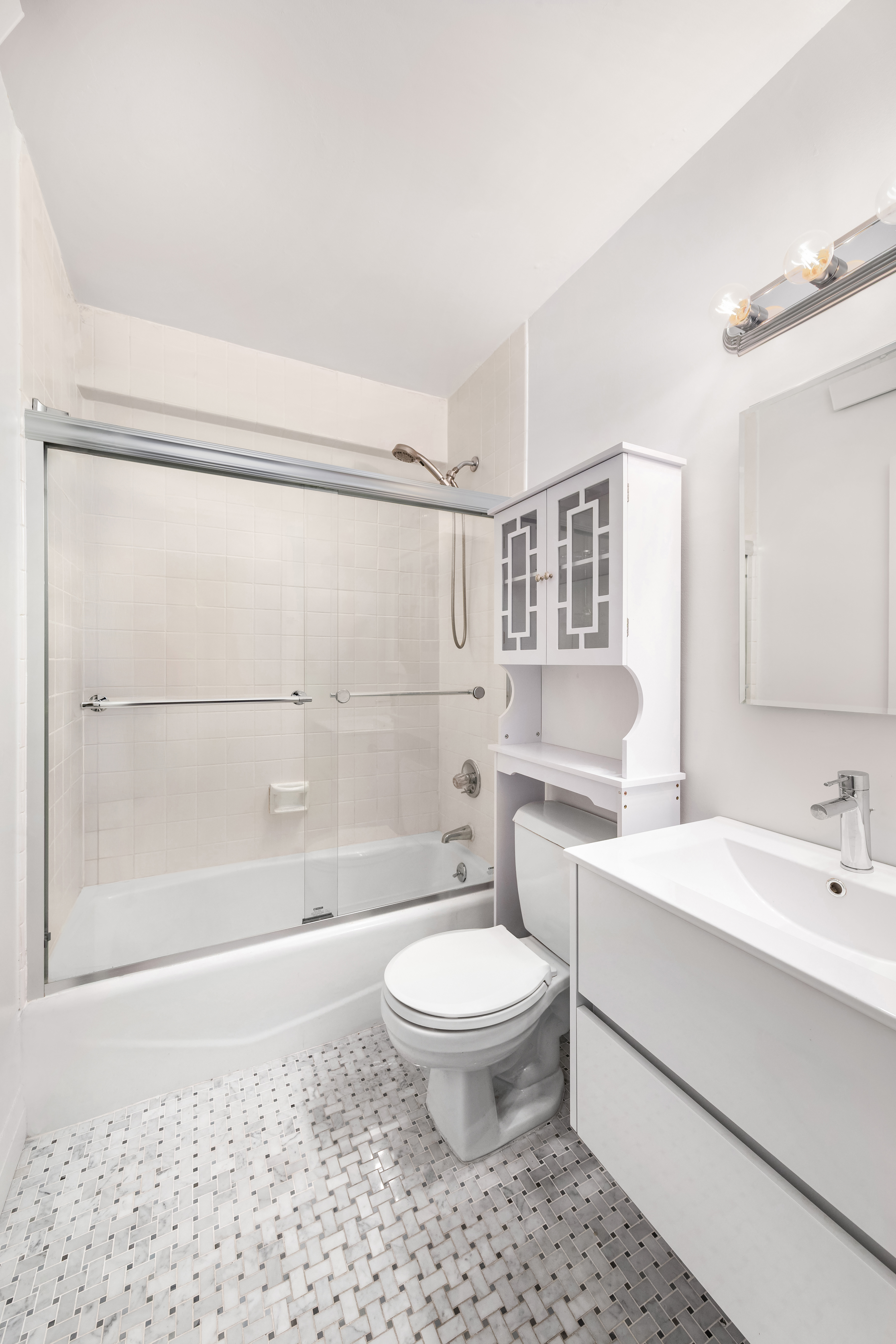 301 East 45th Street, Unit 11F Manhattan, NY 10017 - Photo 6 of 9 a bathroom with a sink a toilet and shower