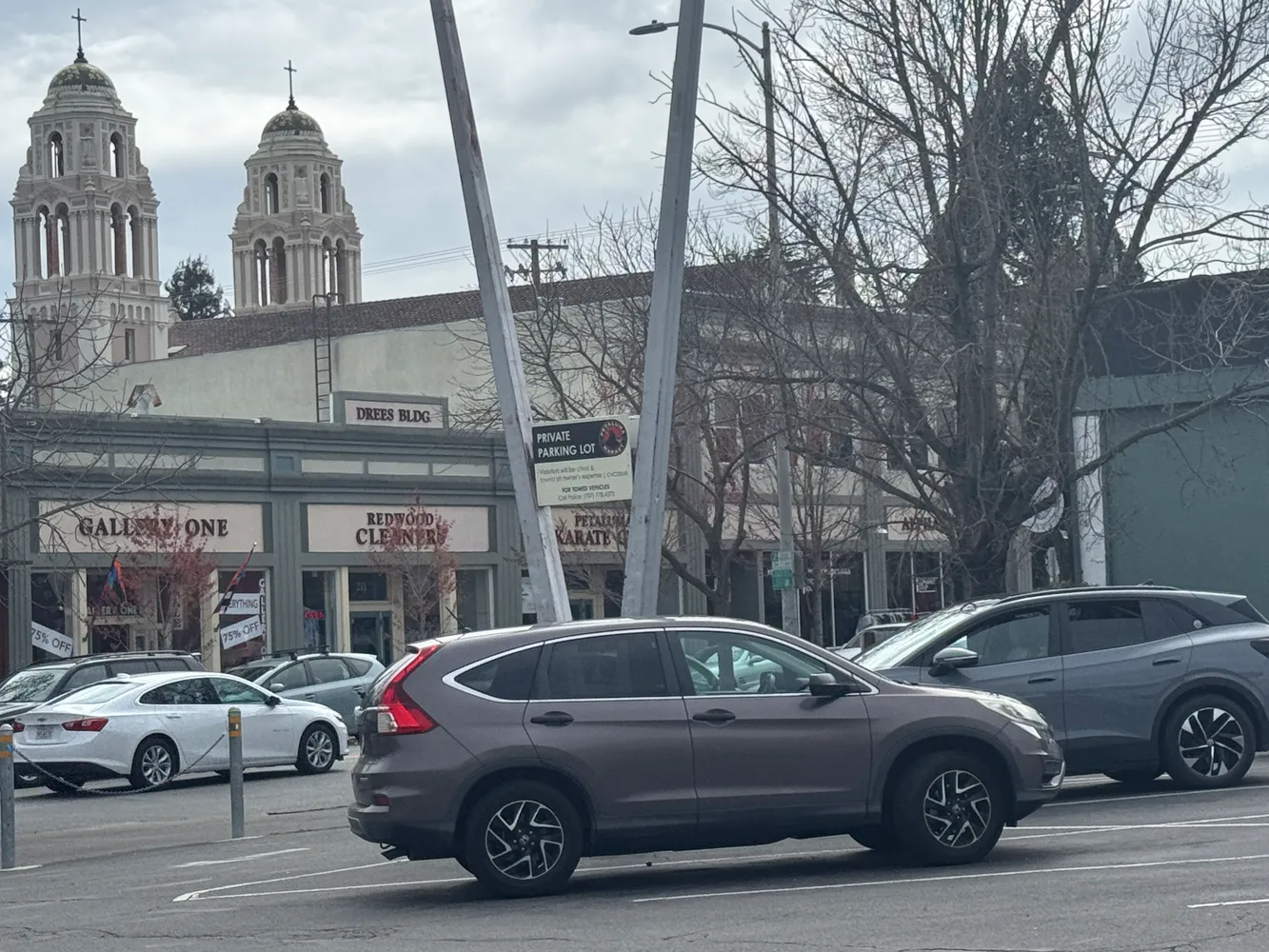 a front view of a building with cars parked