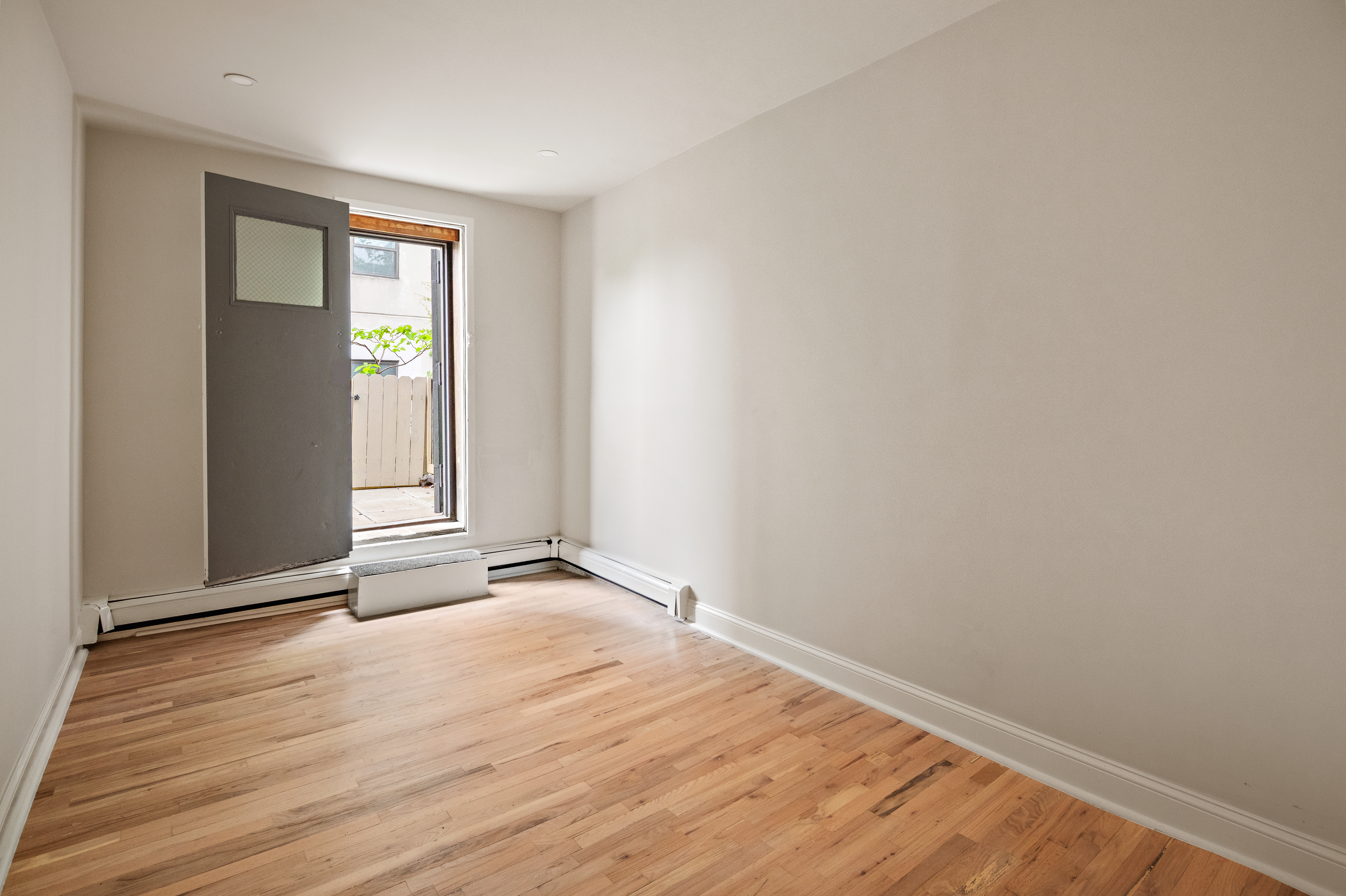 544 Court Street, Unit 2 Brooklyn, NY 11231 - Photo 7 of 9 a view of an empty room with wooden floor and a window
