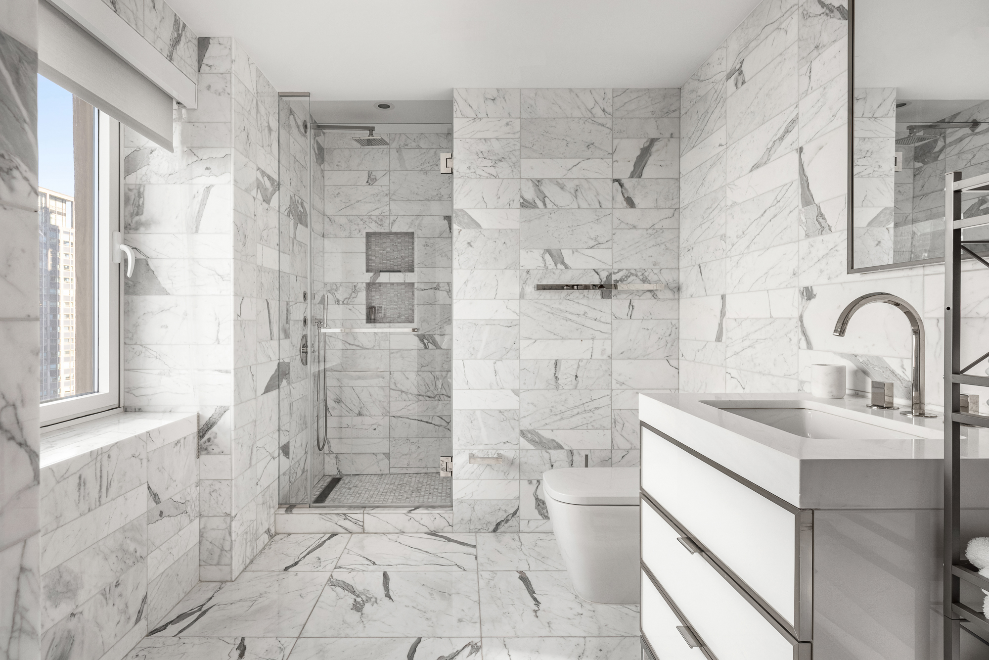 135 West 52nd Street, Unit 40A Manhattan, NY 10019 - Photo 18 of 24 a bathroom with a sink a toilet and shower