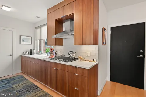 a kitchen with stainless steel appliances granite countertop a refrigerator and a stove top oven