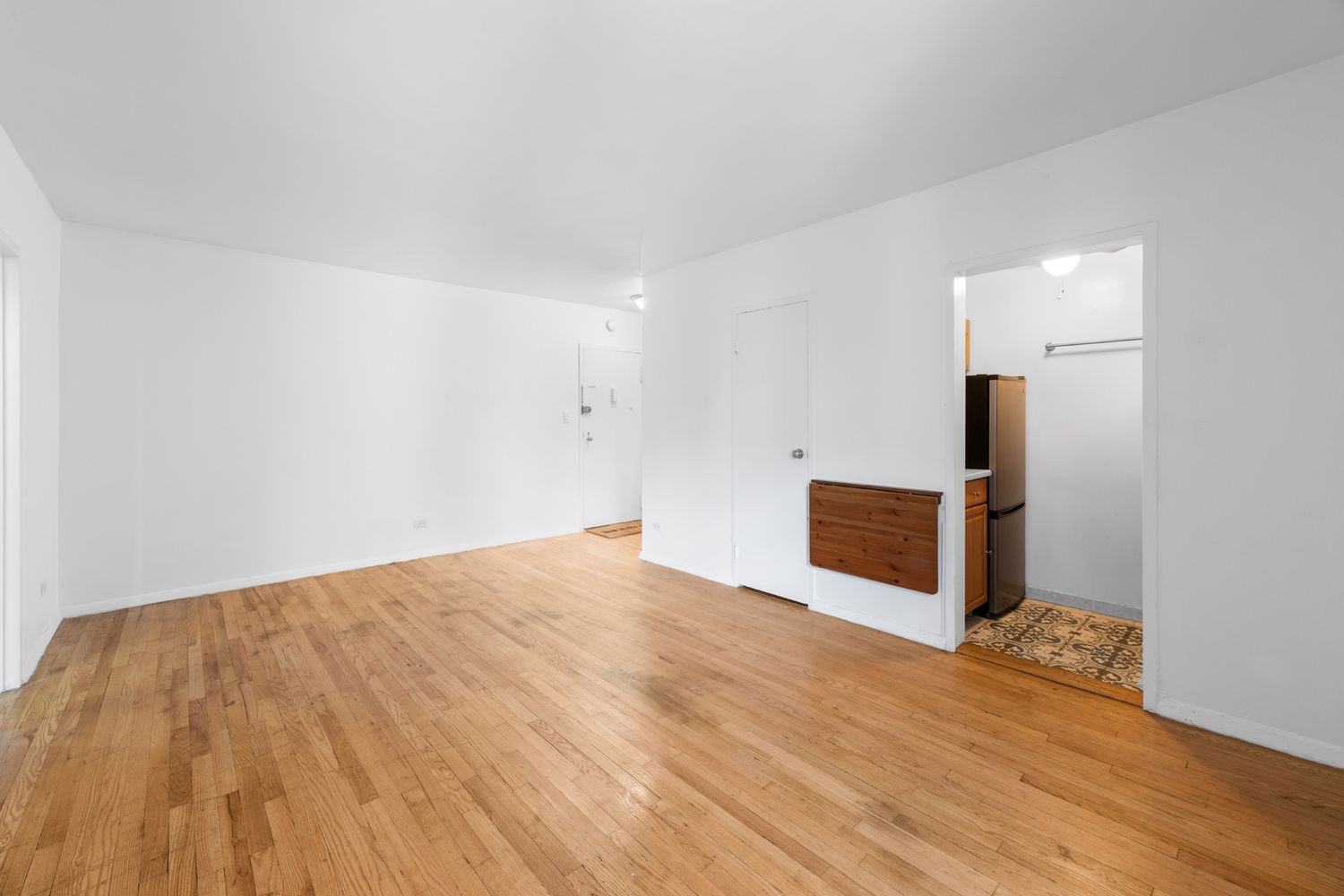 a view of empty room with wooden floor