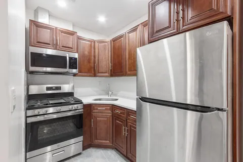 a kitchen with granite countertop a refrigerator stove and microwave
