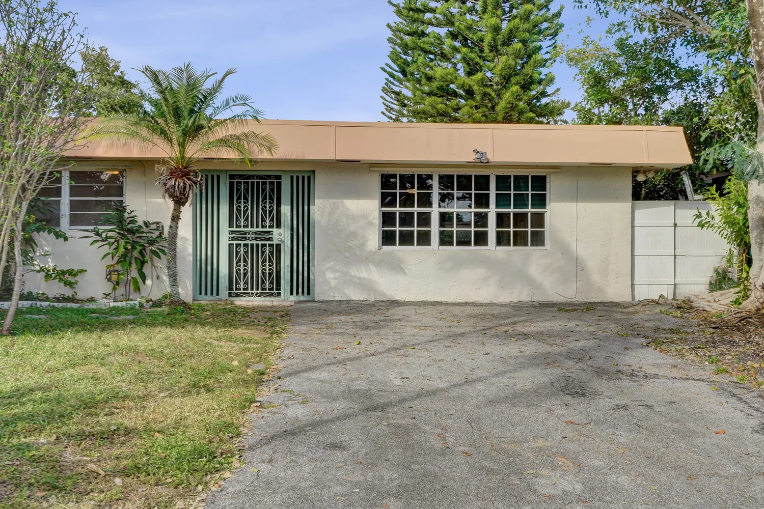 front view of a house with a yard and potted plants