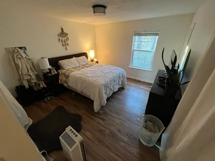 a bedroom with bed and wooden floor