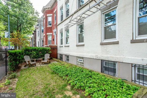 a backyard of a house with outdoor seating and plants