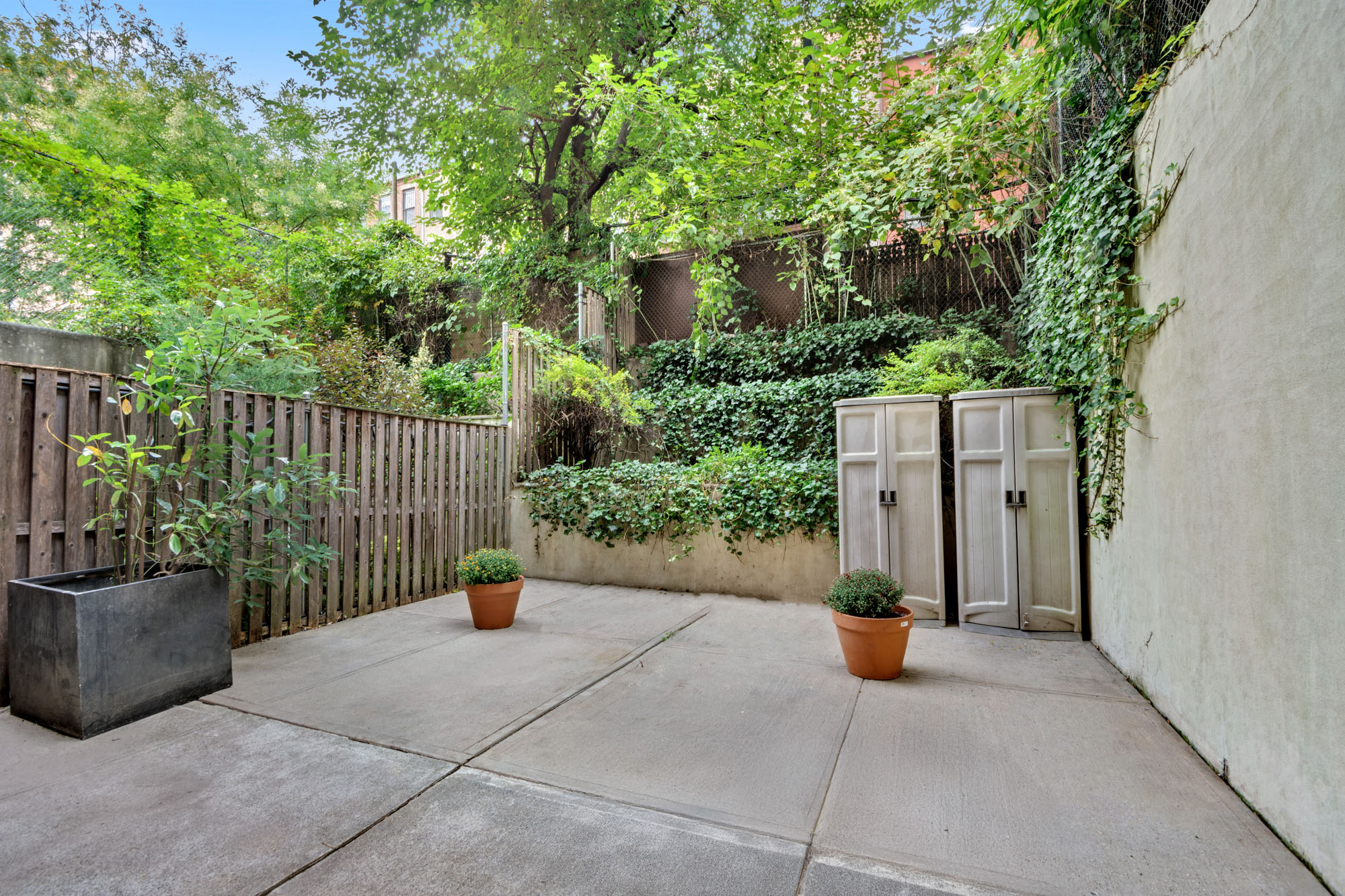 5 West 127th Street, Unit 1B Manhattan, NY 10027 - Photo 9 of 11 a view of a street with potted plants and trees