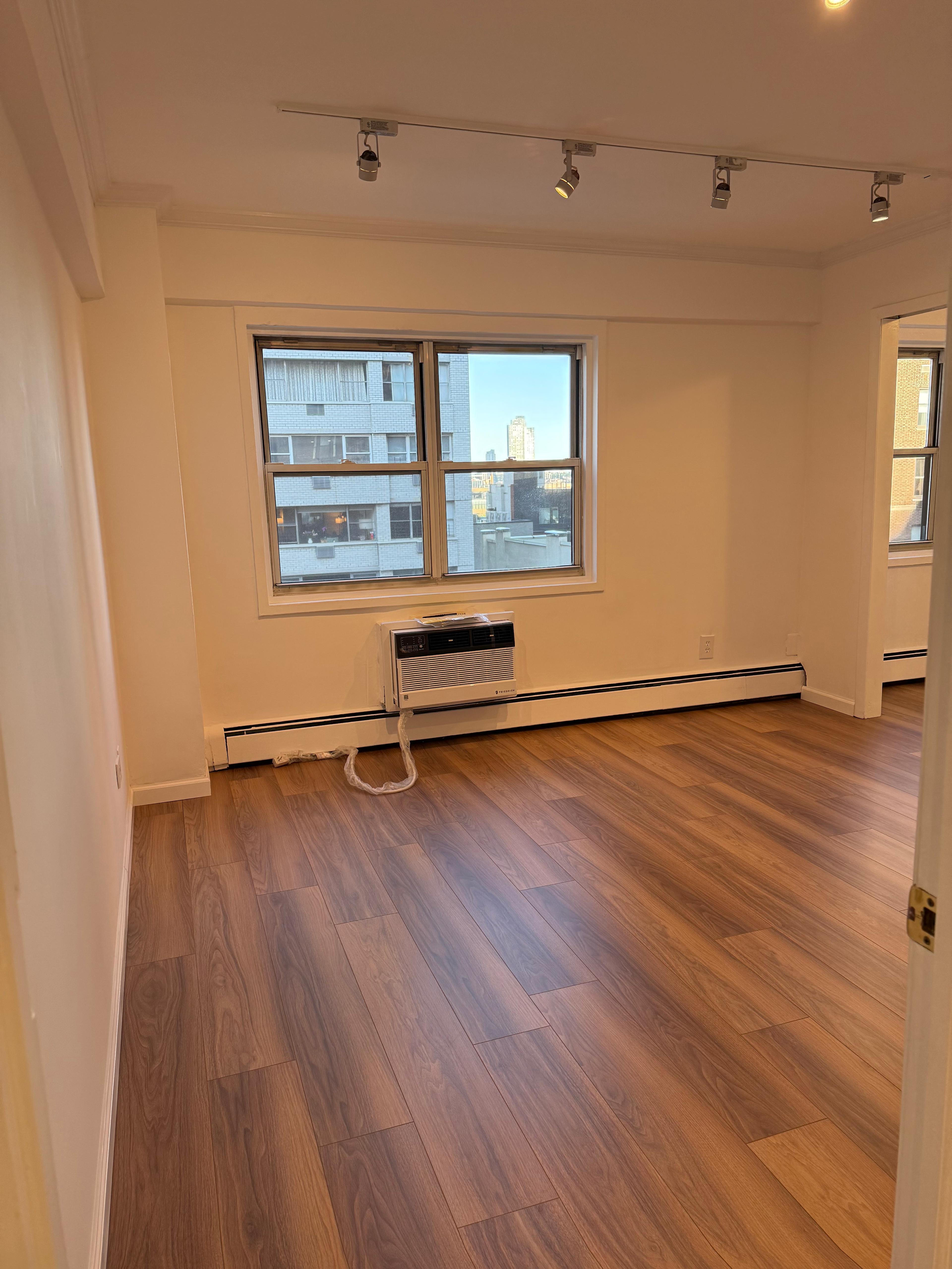 40 Sutton Place, Unit 7A Manhattan, NY 10022 - Photo 5 of 11 a view of a room with wooden floor and windows