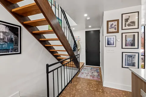 a view of staircase with lots of frames on wall and stairs