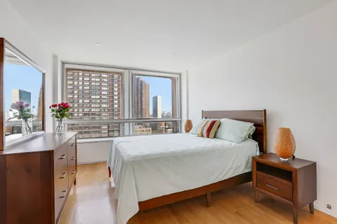 a living room with a bed furniture and a large window