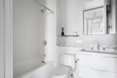 a bathroom with a sink toilet vanity and shower