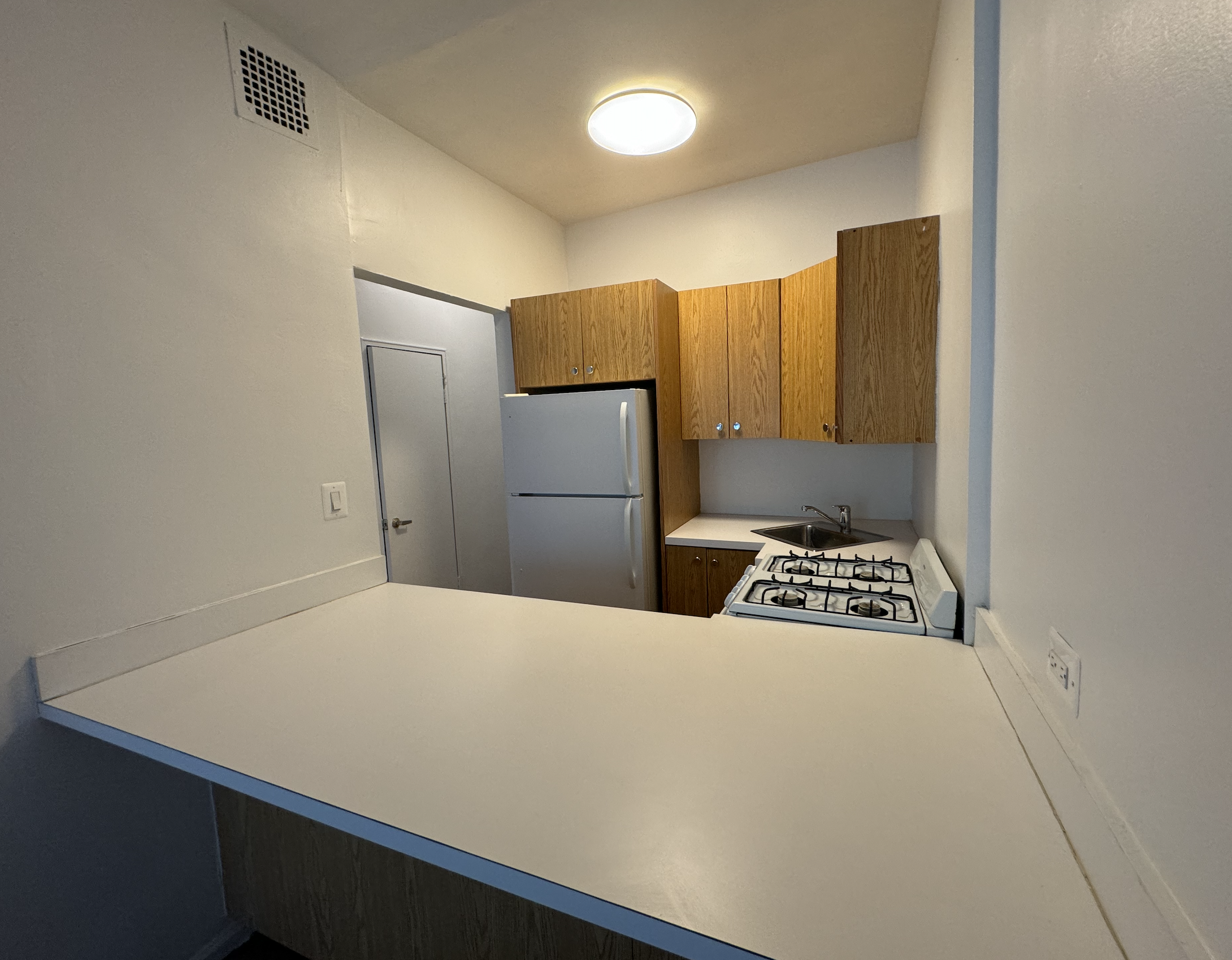 445 West 48th Street, Unit 2D Manhattan, NY 10036 - Photo 3 of 18 a bedroom with a bed and a refrigerator