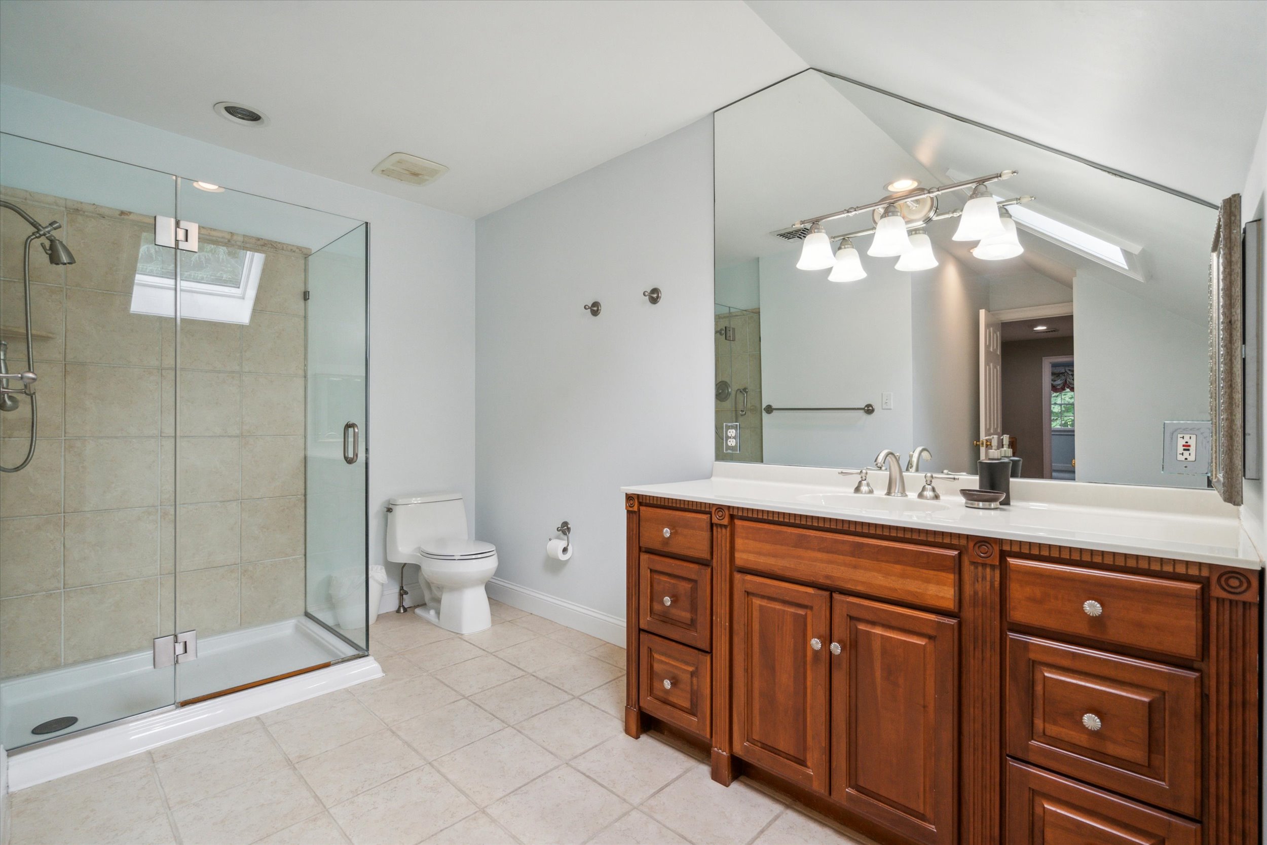 145 Biddulph Road Wayne, PA 19087 - Photo 31 of 39 a spacious bathroom with a granite countertop sink a toilet and a mirror