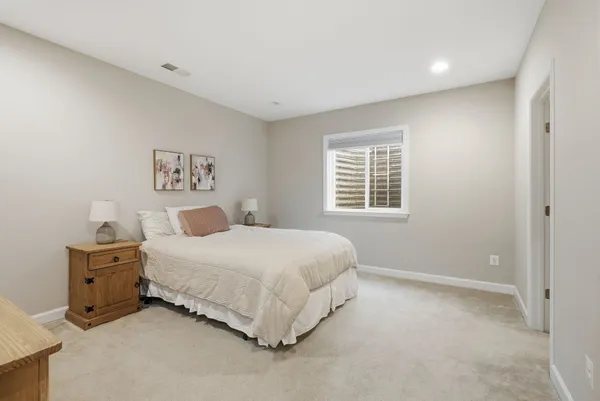 a view of a patio with couches potted plants and wooden floor