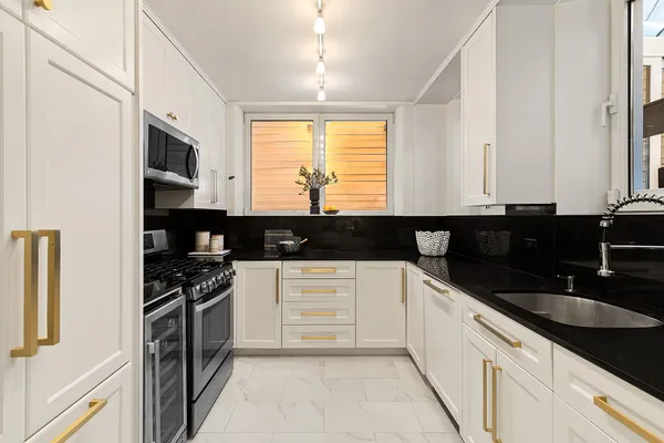 a kitchen with stainless steel appliances granite countertop a sink and a stove