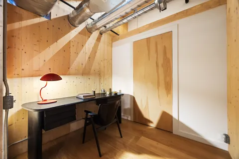 a view of a hallway with wooden floor and stairs