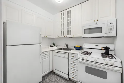 a kitchen with white cabinets and white appliances