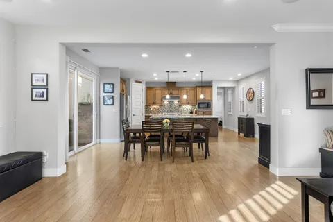 a kitchen with a dining table chairs and refrigerator