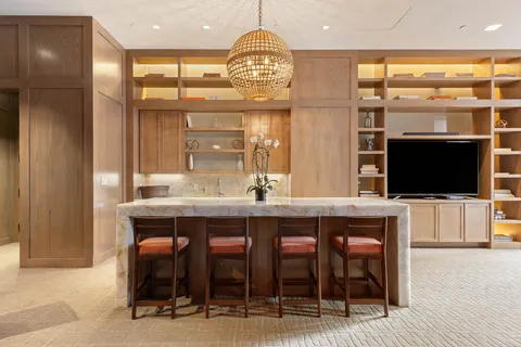 a dining hall with a dining table chairs and a refrigerator