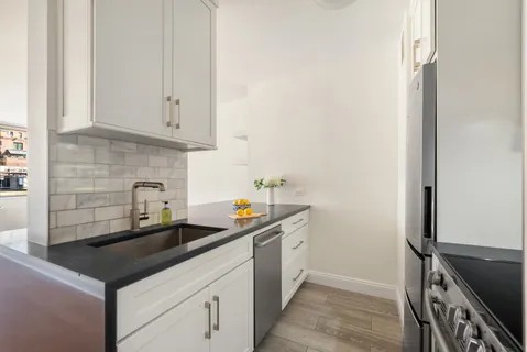 a kitchen with stainless steel appliances a sink stove and cabinets