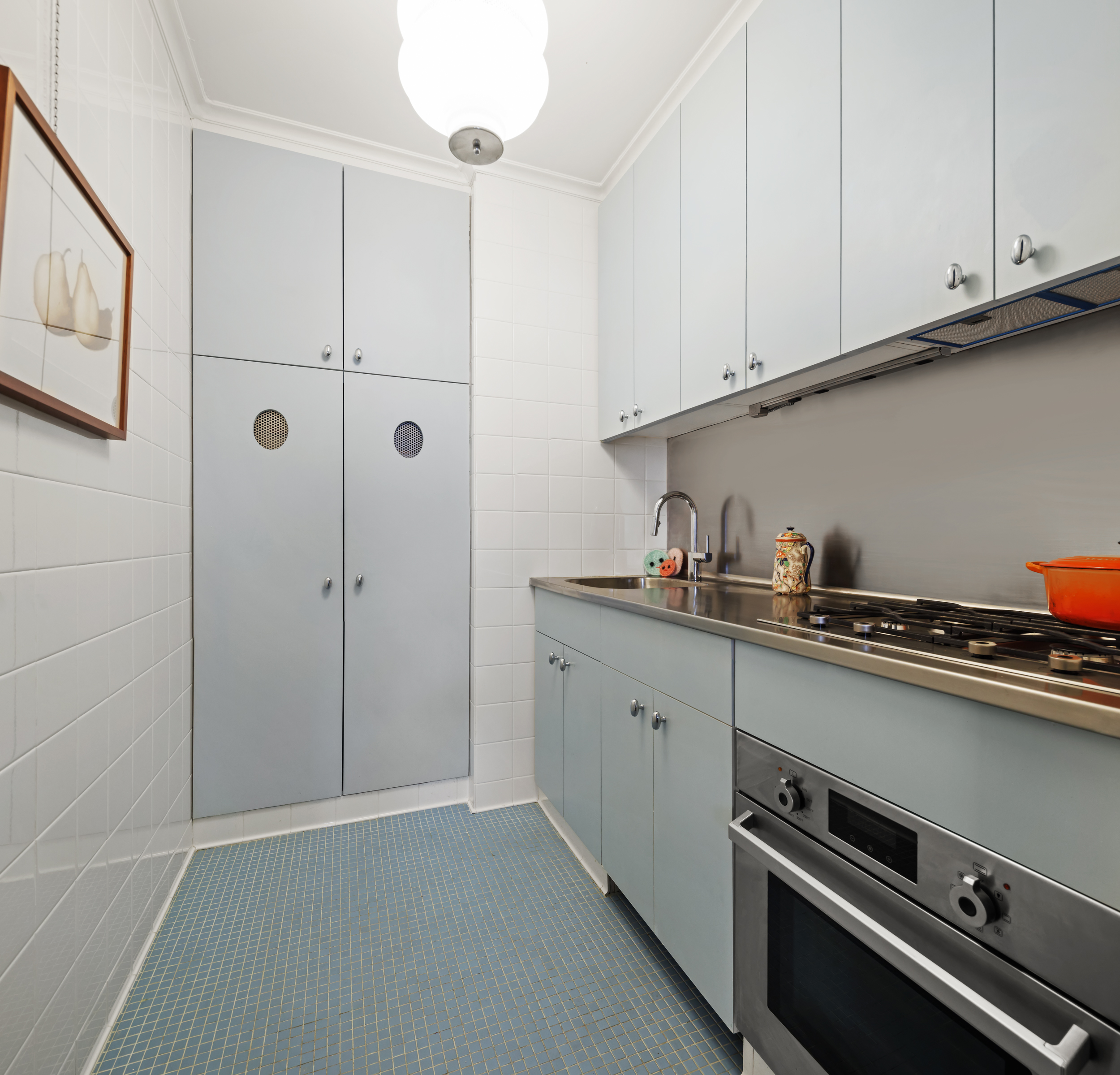 212 East 48th Street, Unit 8E Manhattan, NY 10017 - Photo 10 of 14 a kitchen with stainless steel appliances granite countertop a sink and cabinets
