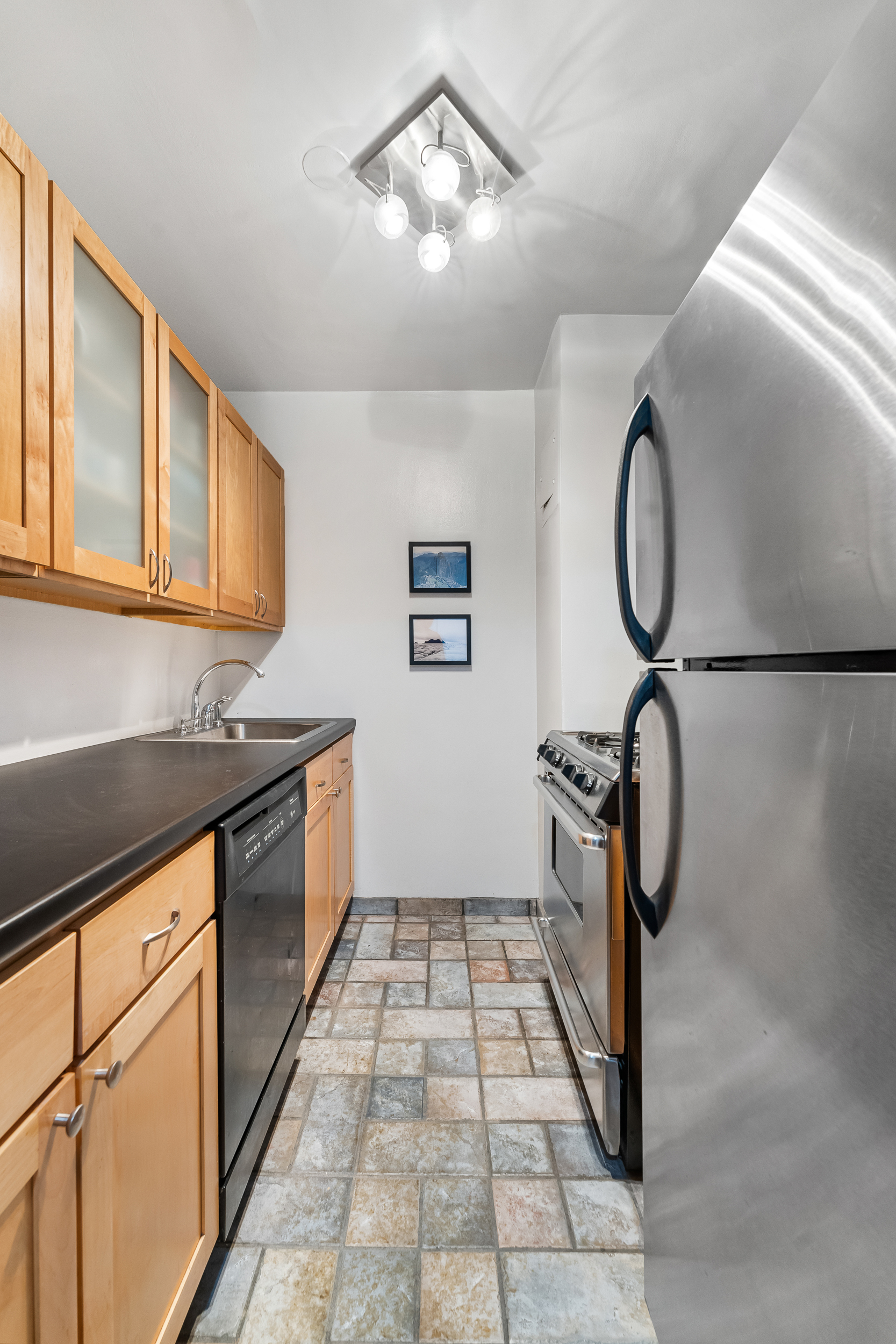7 East 14th Street, Unit 302 Manhattan, NY 10003 - Photo 5 of 6 a kitchen with granite countertop a stove a sink and cabinets