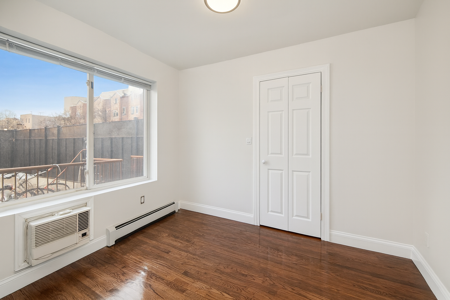 189 Woodpoint Road Brooklyn, NY 11211 - Photo 12 of 21 an empty room with wooden floor and windows