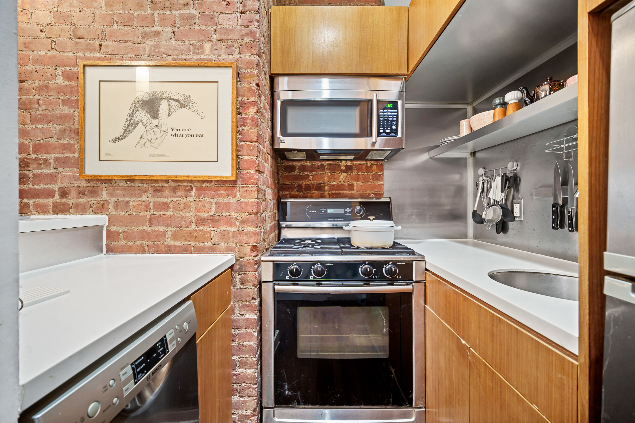 330 West 17th Street, Unit 3E Manhattan, NY 10011 - Photo 4 of 8 a kitchen with a stove and a microwave