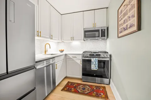a kitchen with stainless steel appliances granite countertop a stove a microwave and cabinets
