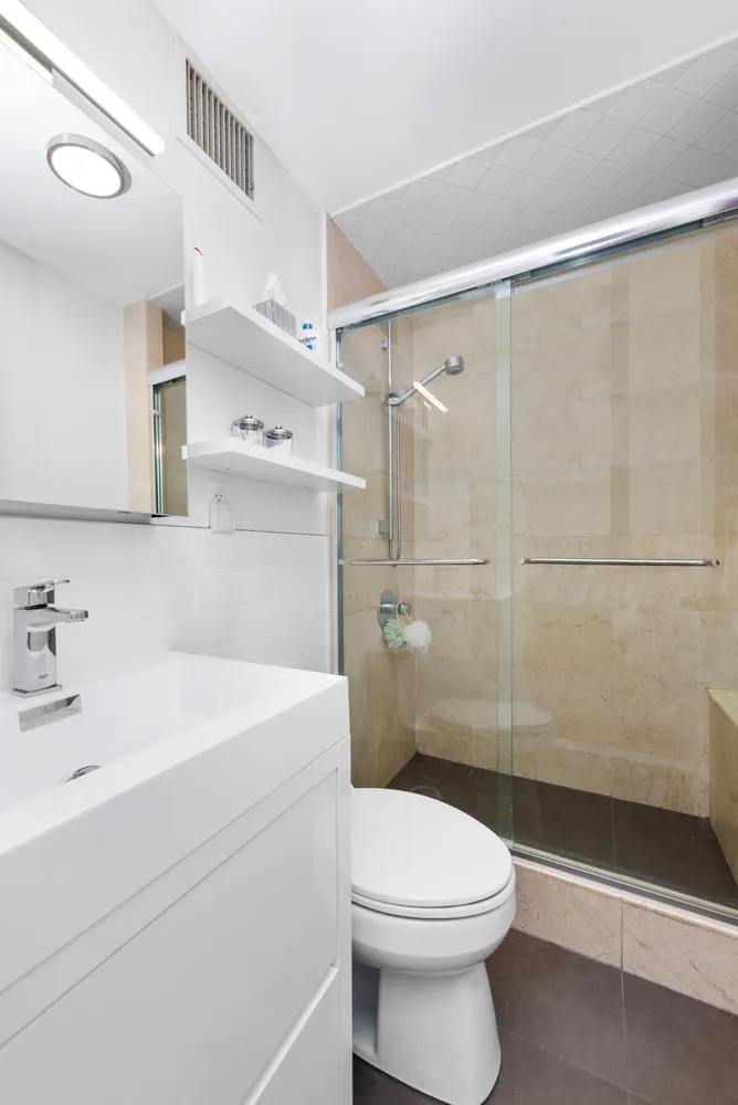 a bathroom with a sink a toilet and shower