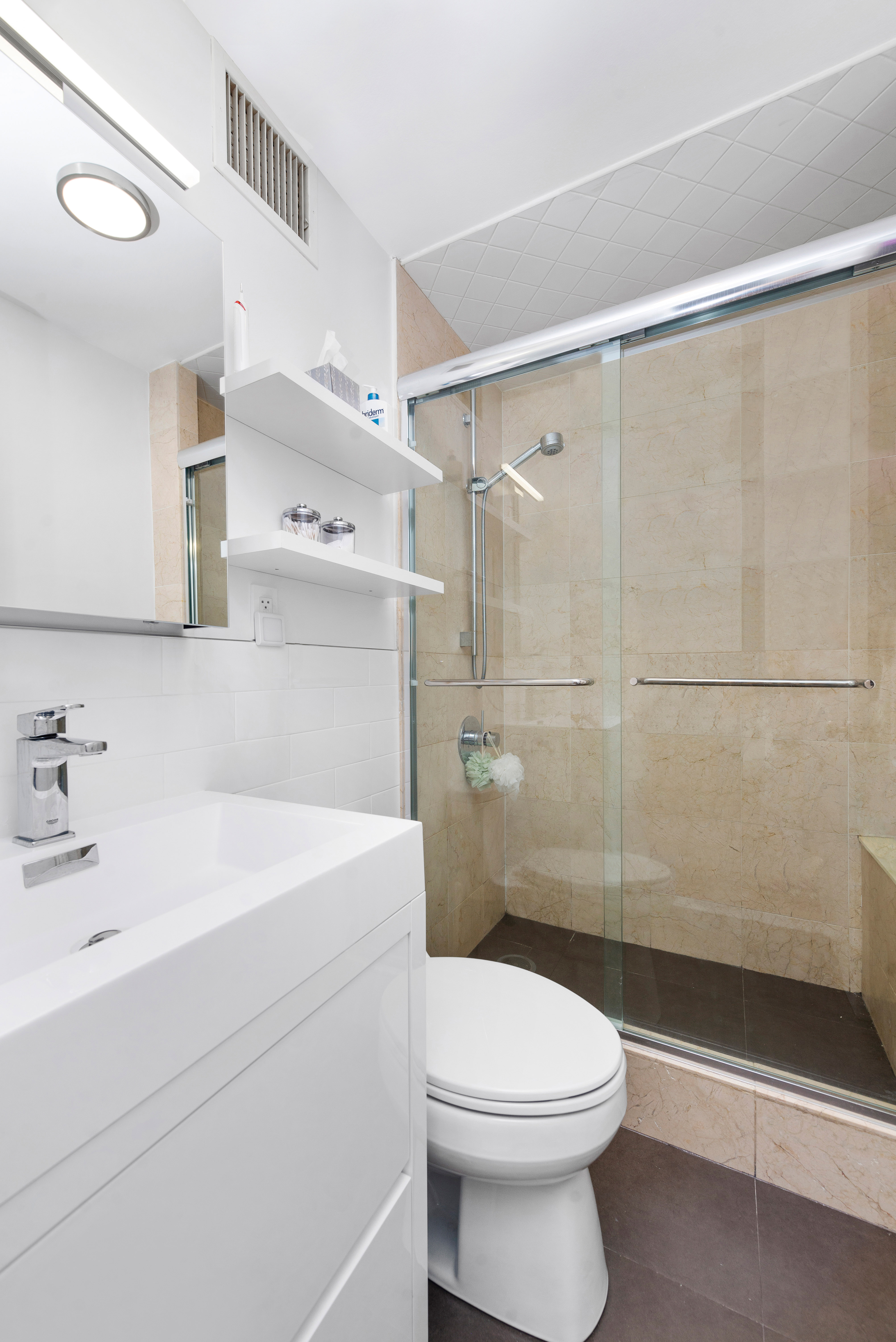 200 East 16th Street, Unit 11GH Manhattan, NY 10003 - Photo 7 of 8 a bathroom with a sink a toilet and shower