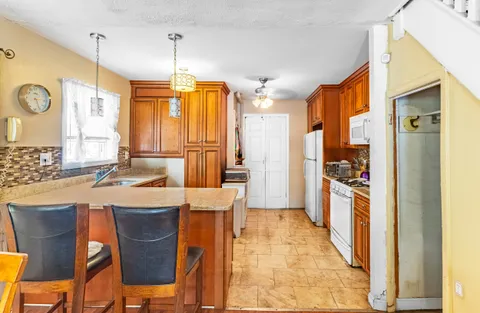 a kitchen with stainless steel appliances granite countertop a sink a stove and refrigerator