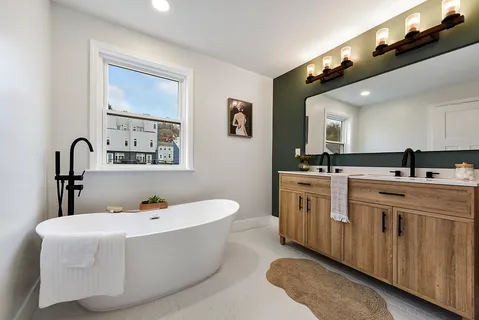 a spacious bathroom with a double vanity sink a mirror and a bathtub