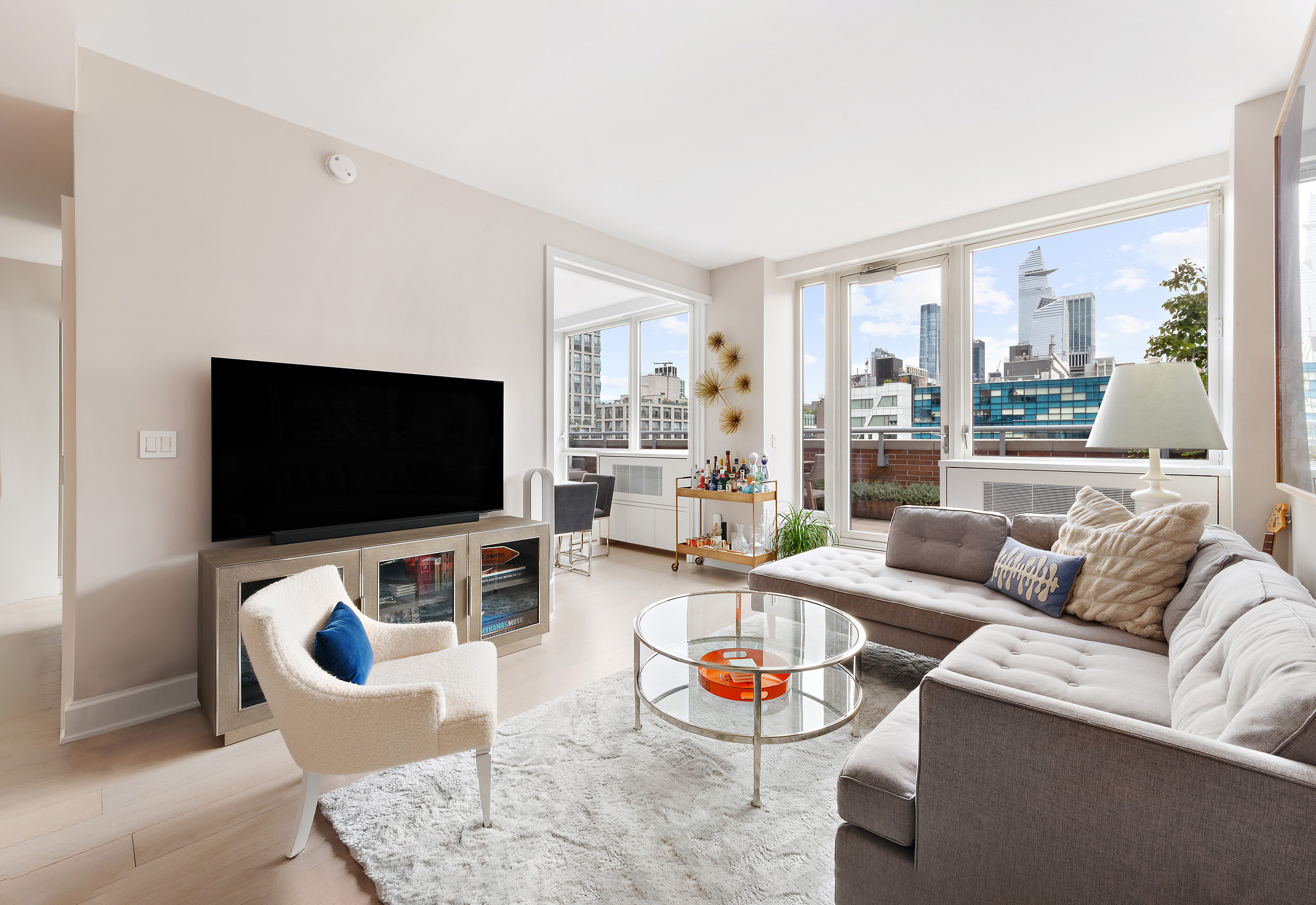 450 West 17th Street, Unit 1003 Manhattan, NY 10011 - Photo 5 of 9 a living room with furniture and a flat screen tv