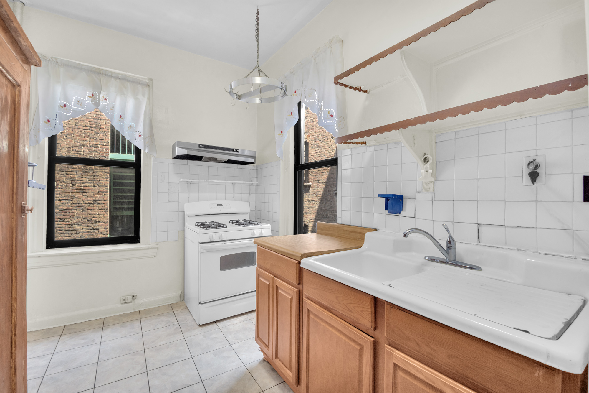 302 Convent Avenue, Unit 43 Manhattan, NY 10031 - Photo 4 of 5 a kitchen with a sink appliances and cabinets