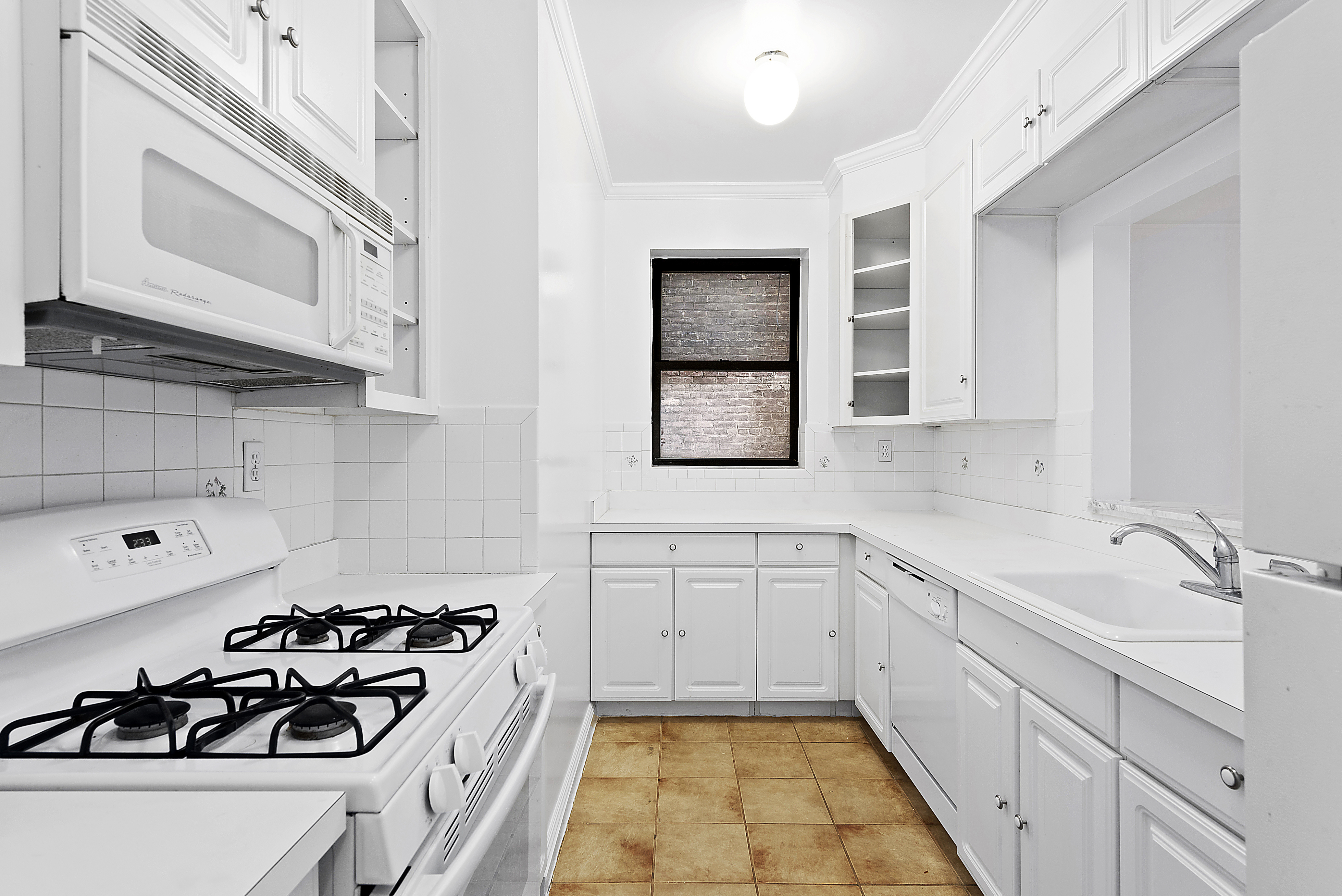 a kitchen with white cabinets a stove sink and dishwasher