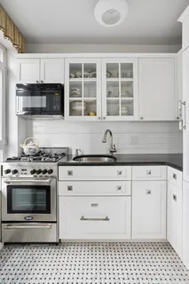 a kitchen with white cabinets and appliances