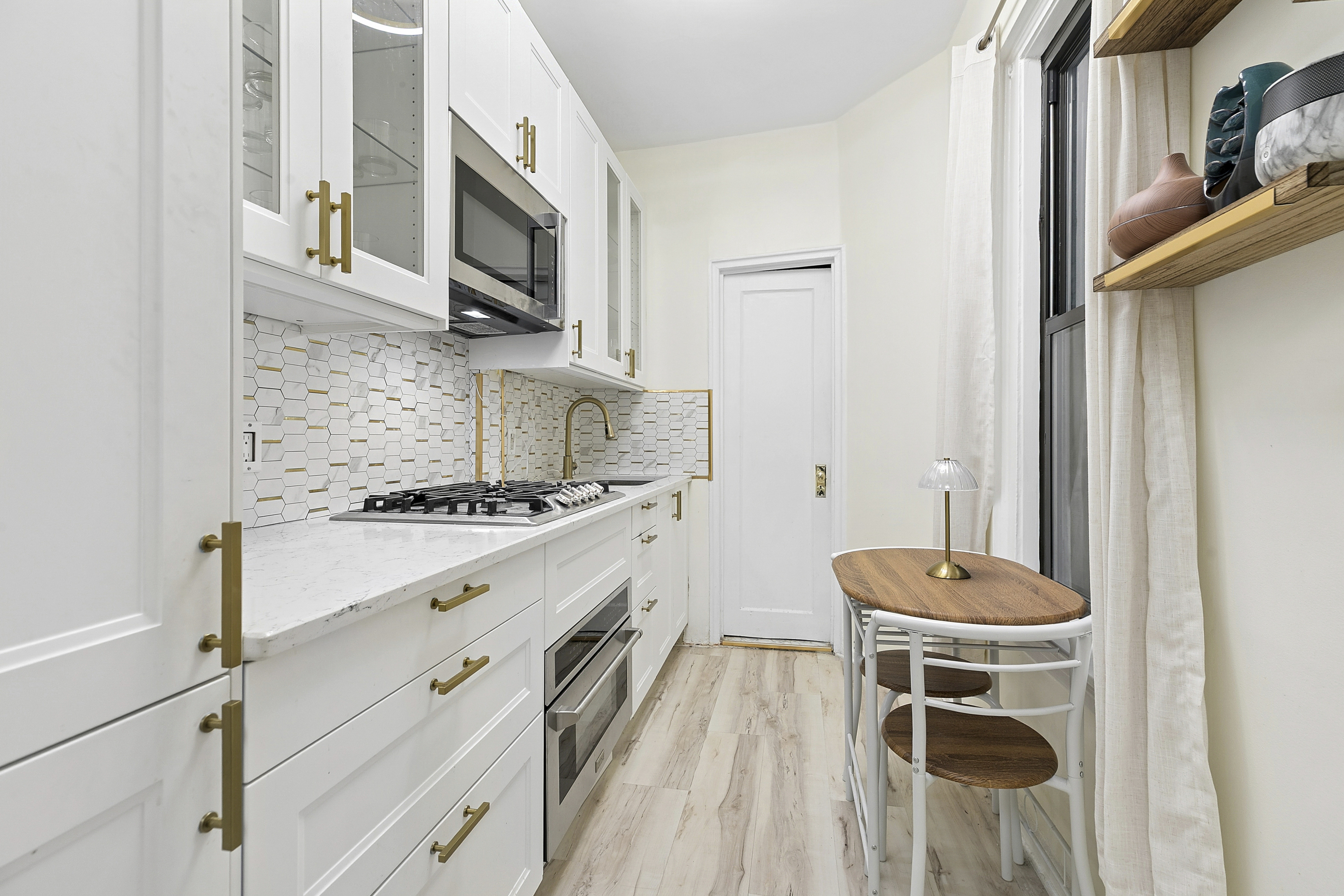 228 West 17th Street, Unit 4B Manhattan, NY 10011 - Photo 2 of 5 a kitchen with a stove and a white wooden cabinets