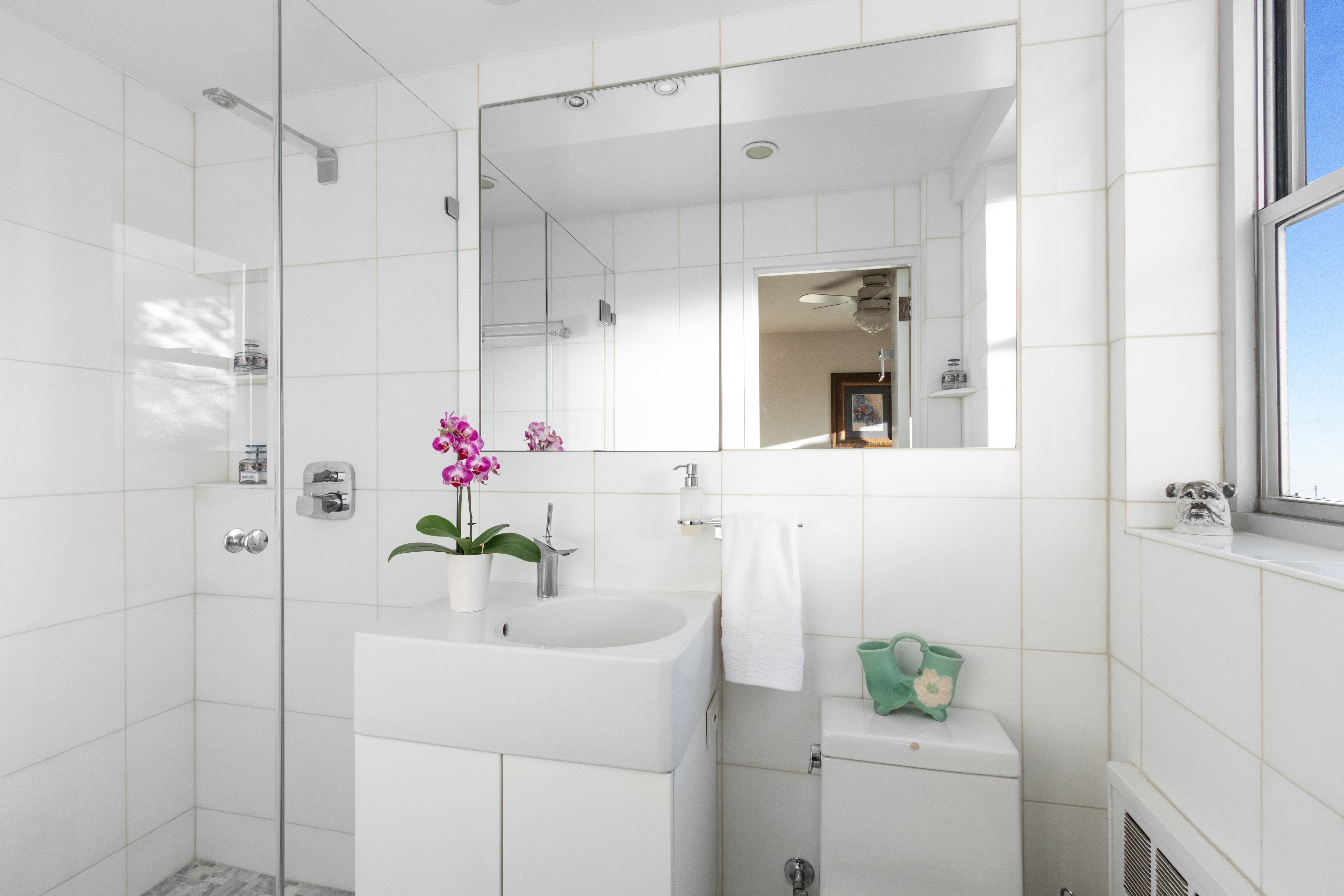 70 East 10th Street, Unit 14M Manhattan, NY 10003 - Photo 9 of 22 a bathroom with a sink shower and a mirror