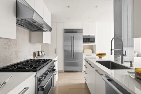 a kitchen with stainless steel appliances a sink a stove and a refrigerator