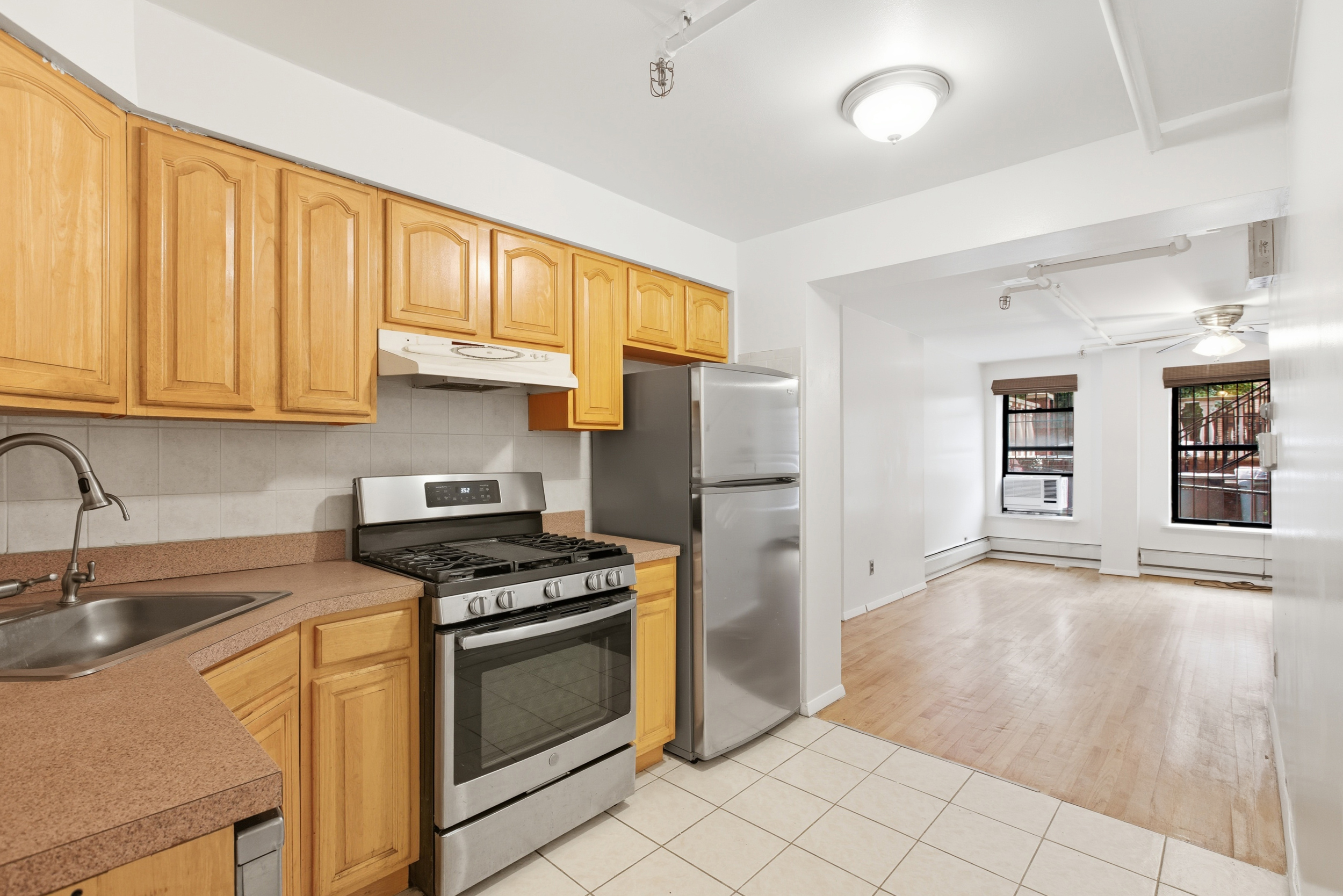420 East 117th Street, Unit 1 Manhattan, NY 10035 - Photo 4 of 9 a kitchen with granite countertop a sink stainless steel appliances and cabinets