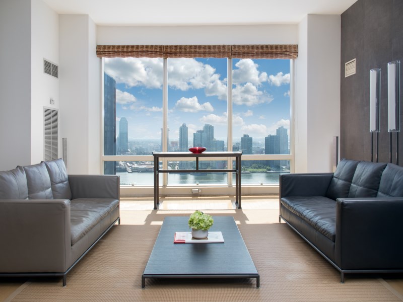845 United Nations Plaza, Unit 33A Manhattan, NY 10017 - Photo 3 of 10 a living room with furniture and a floor to ceiling window