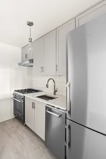 a kitchen with stainless steel appliances granite countertop a sink stove and refrigerator