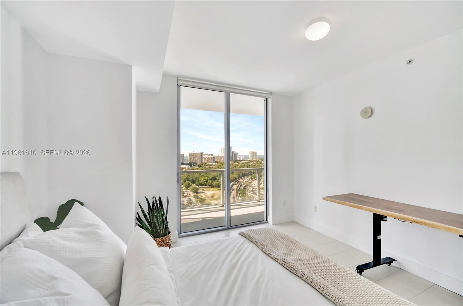 79 Southwest 12th Street, Unit 2201S Miami, FL 33130 - Photo 21 of 33 a bedroom with a bed and a window