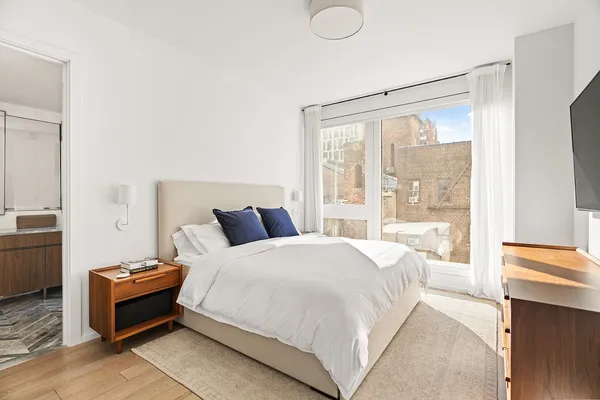 a bedroom with a bed and a large window