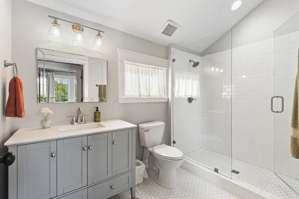 a bathroom with a double vanity sink toilet and shower